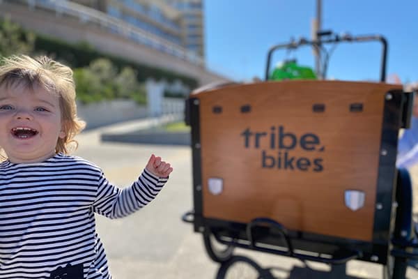Kids climbing into a Tribe Original cargo bike