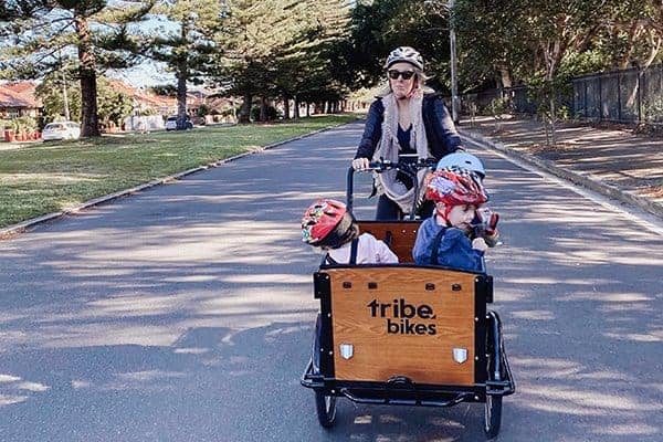 A rider stopped on a Tribe Original with both feet still on the pedals