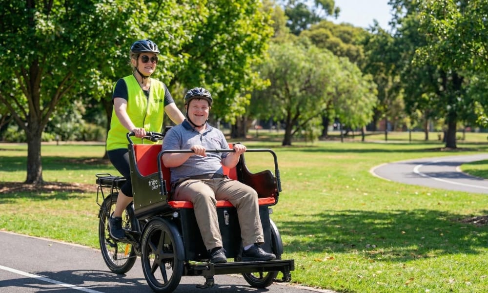 Two passengers riding in a Ricky Rickshaw on a scenic loop